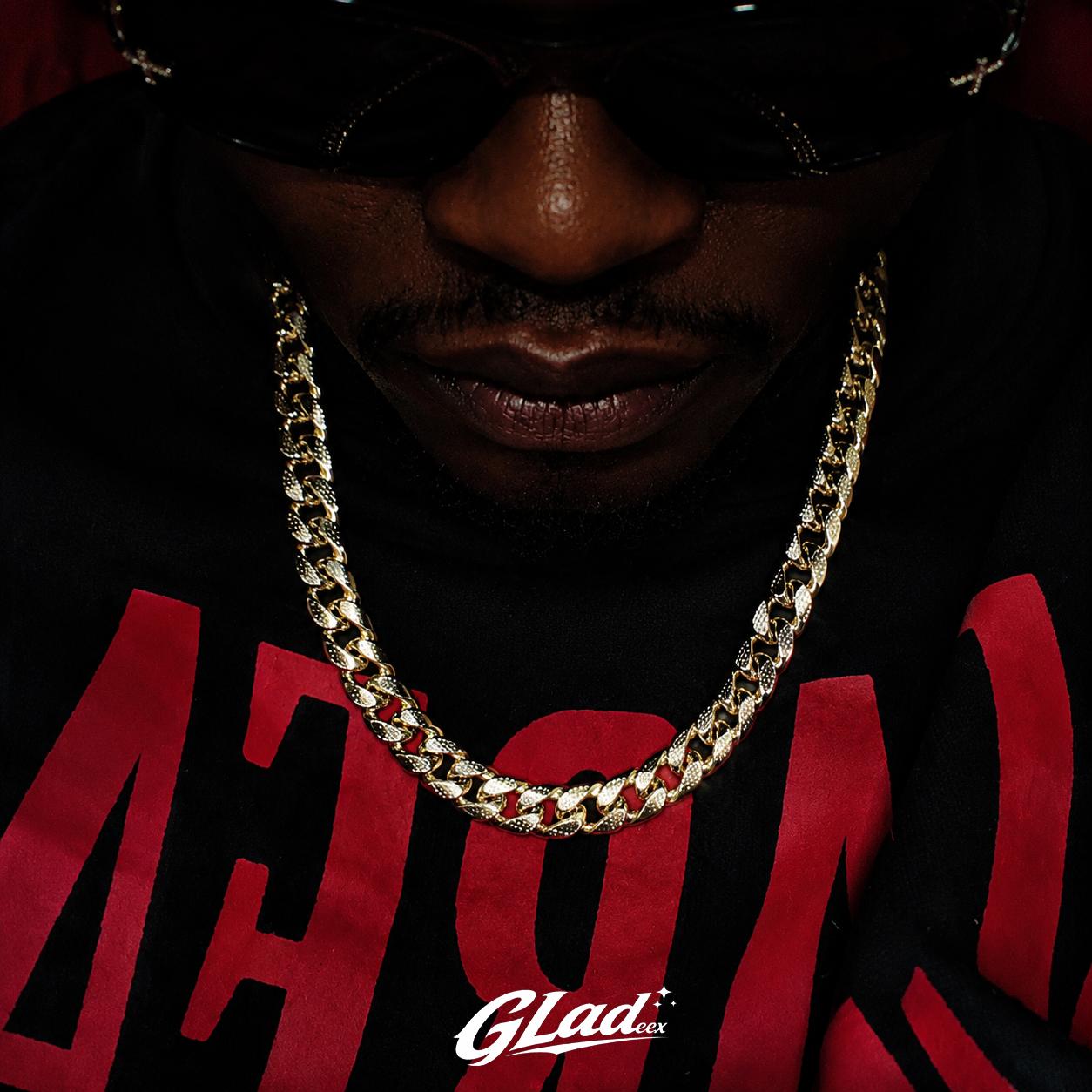 Man wearing an 8mm gold plated Cuban link chain over a black and red shirt