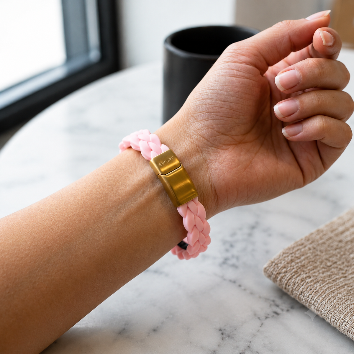 Close-up of a pink silicone bracelet with a 14K gold plated clasp on a wrist